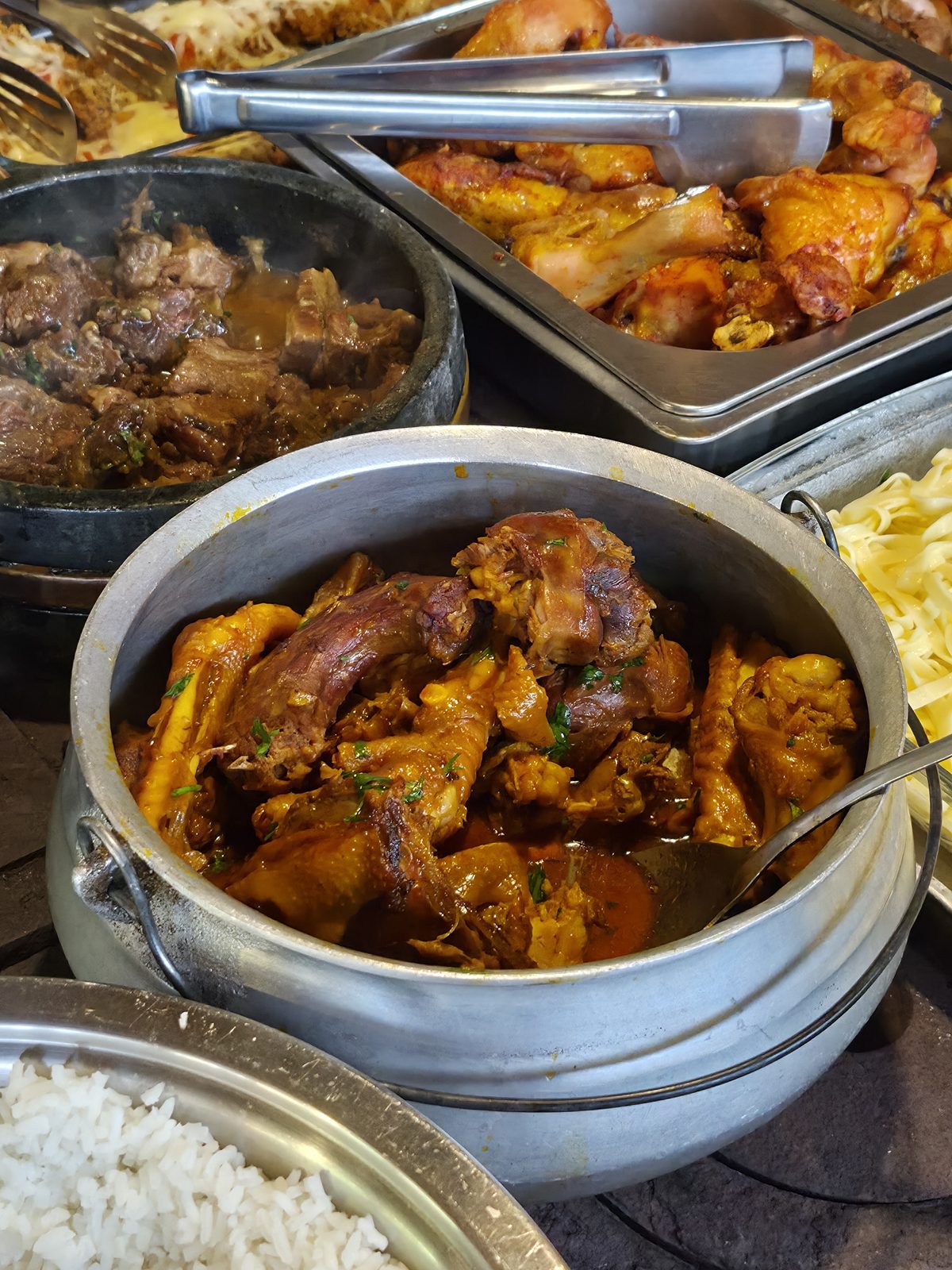 Panelas de ferro com frango caipira, carne e arroz servidas no almoço do Recanto da Prata