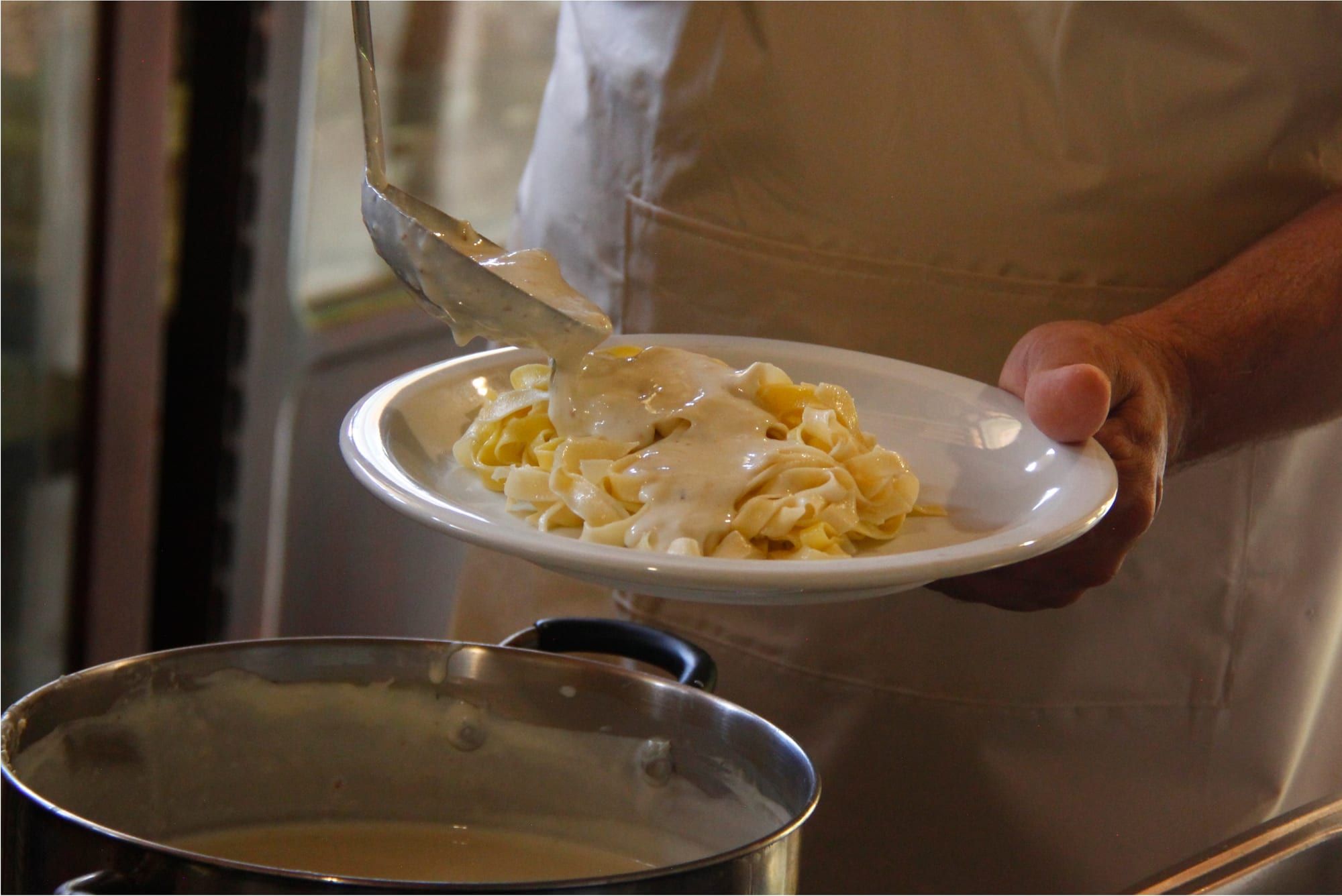 Prato de macarrão caseiro finalizado com molho