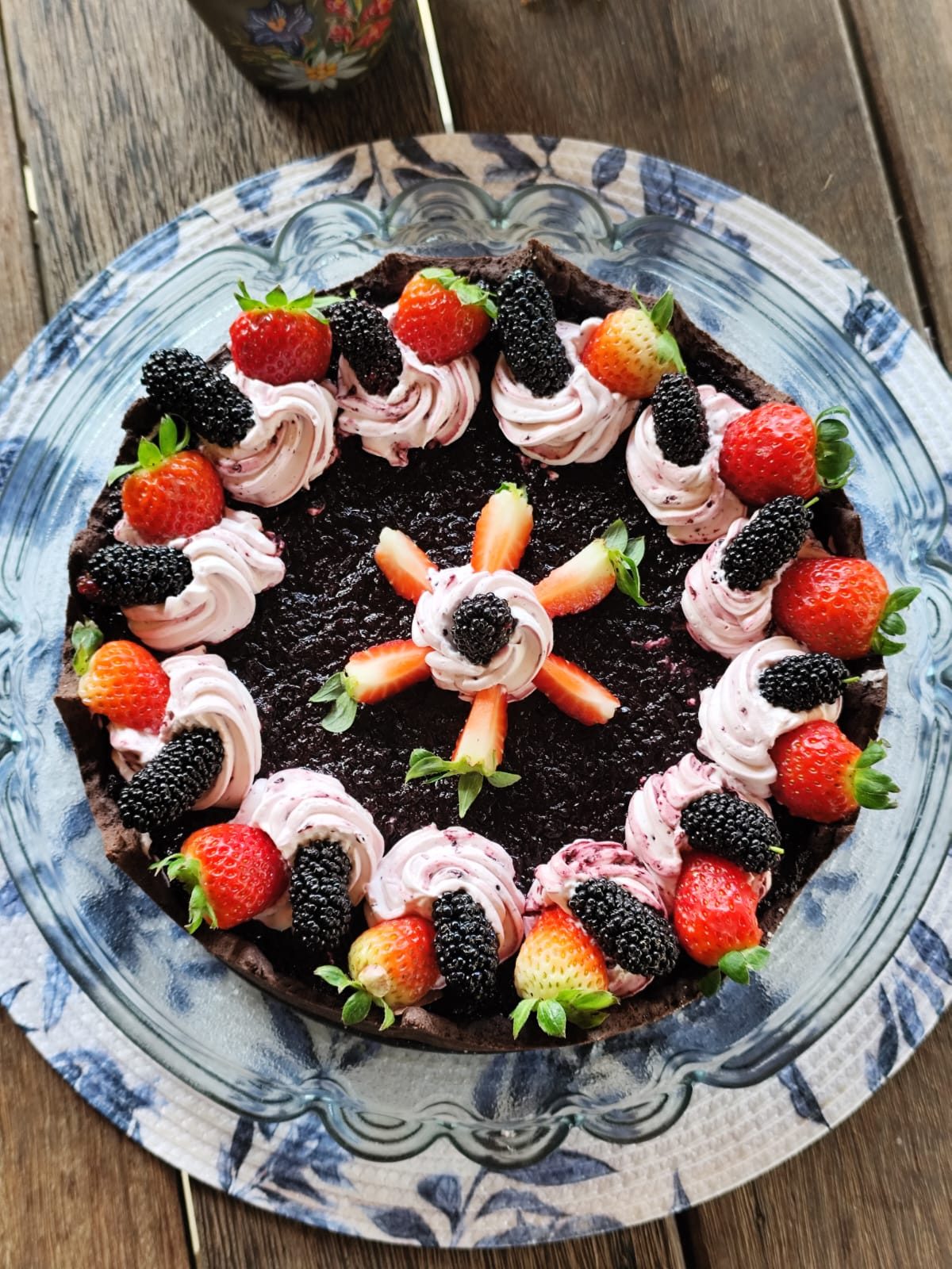 Torta de chocolate decorada com chantilly, amoras e morangos frescos